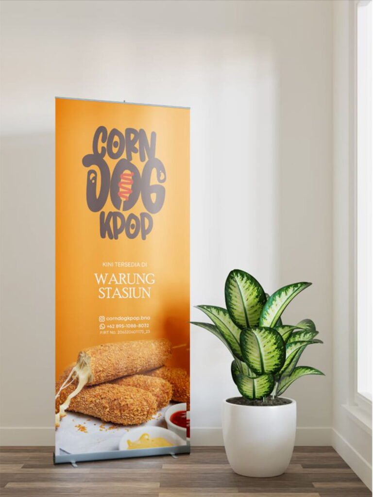 GRAPHIC DESIGN Yellow Corn Dog Shop packaging box standing next to a small potted plant on a wooden surface